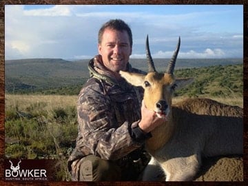 Client with a Mountain Reedbuck on a rocky ledge shot after a long walk and stalk.