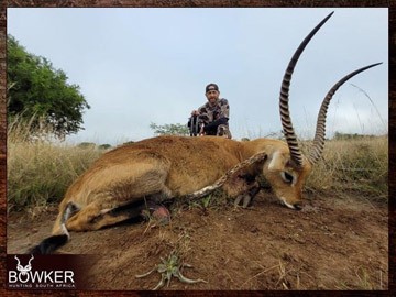 Client with a red lechwe shot while bow hunting.